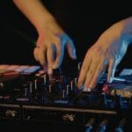 alquiler de equipos de sonido con técnico ajustando mesa de mezclas en evento nocturno