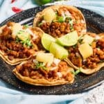 Tacos de maíz con carne y verduras frescas en mesa rústica sin gluten