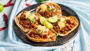 Tacos de maíz con carne y verduras frescas en mesa rústica sin gluten