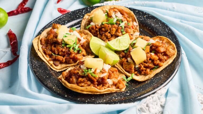 Tacos de maíz con carne y verduras frescas en mesa rústica sin gluten