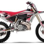 Adhesivos enduro de alto rendimiento instalados en moto de competición off road con diseño rojo, blanco y negro sobre fondo neutro