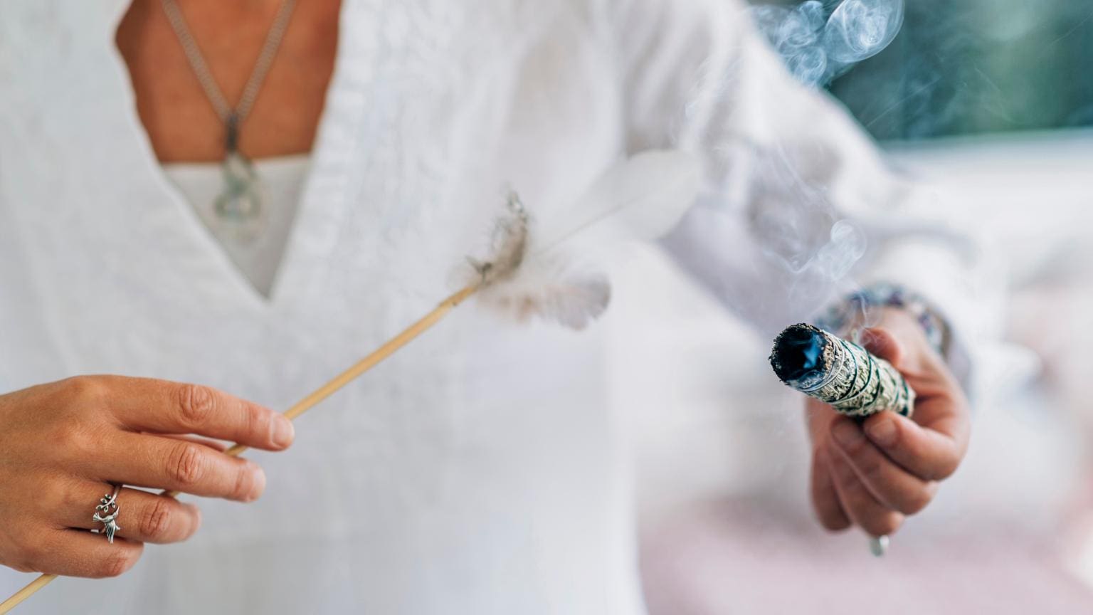 Tienda espiritual con ritual de limpieza y armonización energética mediante sahumerio y pluma para potenciar la energía positiva del entorno