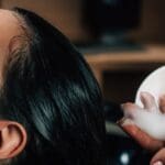 Interior profesional de salón de belleza Madrid con estilista trabajando en diagnóstico capilar