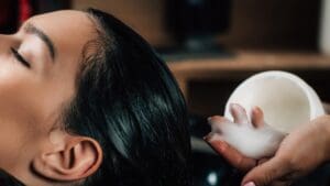 Interior profesional de salón de belleza Madrid con estilista trabajando en diagnóstico capilar